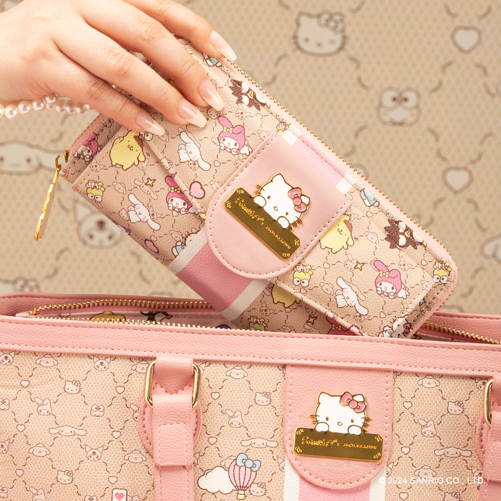 Una mano sostiene una billetera rosa de Hello Kitty, con simpáticos personajes, encima de un bolso de mano a juego, sobre un fondo con un estampado caprichoso.