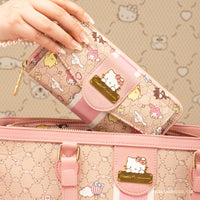 Idol Beauty Una mano sostiene una billetera rosa de Hello Kitty, con simpáticos personajes, encima de un bolso de mano a juego, sobre un fondo con un estampado caprichoso.